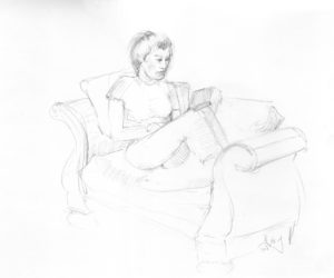 A woman sitting on top of a couch reading.